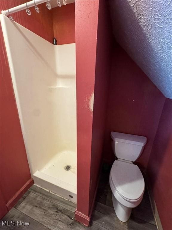 full bathroom with a stall shower and toilet