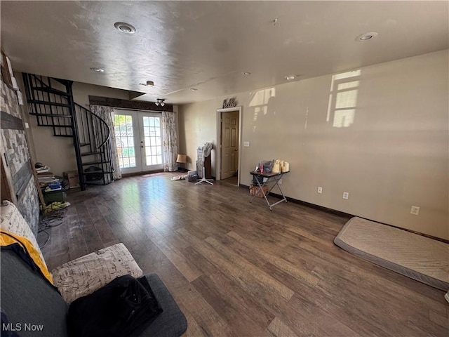 unfurnished living room with recessed lighting, wood finished floors, stairs, baseboards, and french doors