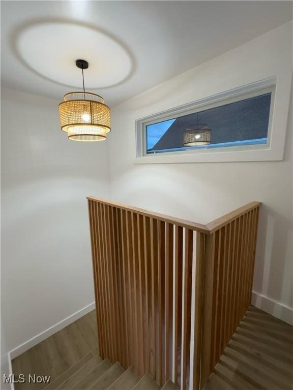 staircase with wood finished floors and baseboards
