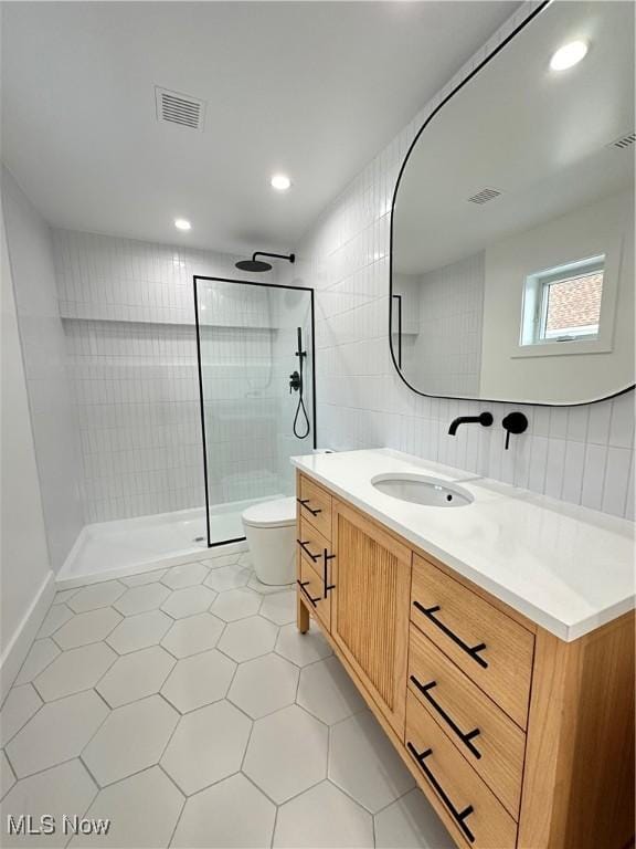 full bath with vanity, a walk in shower, toilet, visible vents, and tile patterned flooring