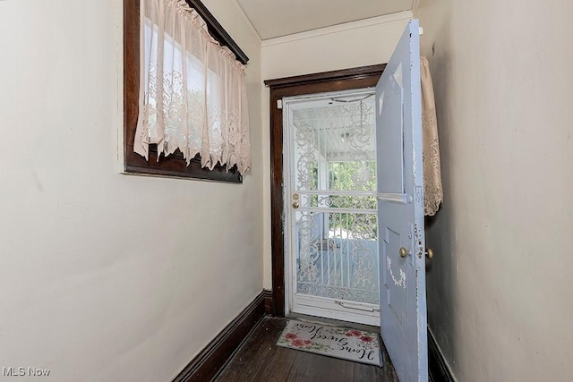 doorway featuring dark wood finished floors and baseboards