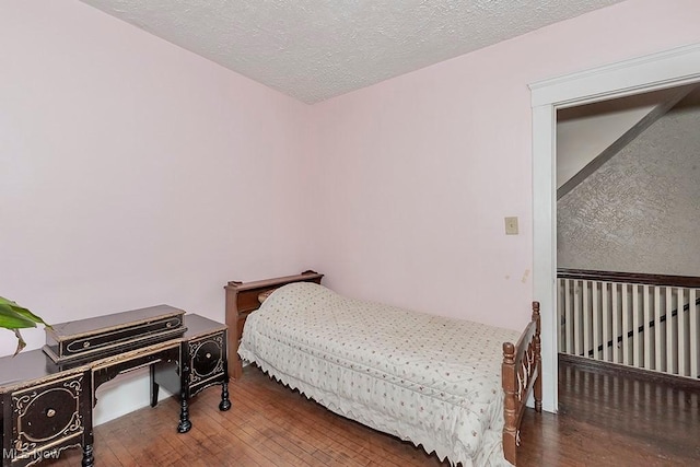 bedroom featuring a textured ceiling and hardwood / wood-style flooring