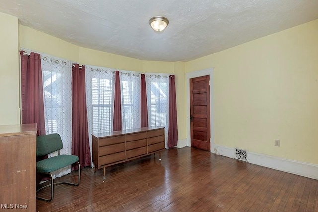 sitting room featuring visible vents, baseboards, and wood-type flooring