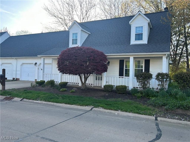 312 Chesapeake Cv, Painesville, OH 44077 - cape cod-style house featuring a porch, an attached garage, concrete driveway, and roof with shingles