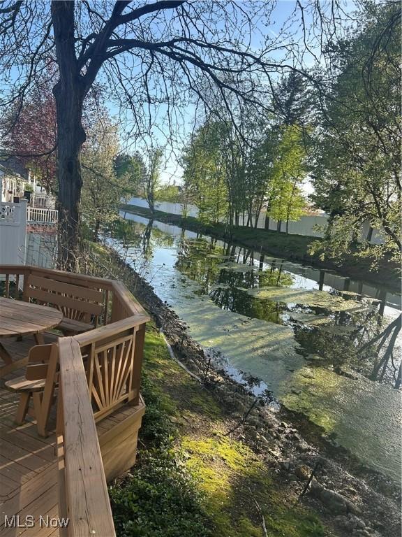 surrounding community featuring outdoor dining area and a water view
