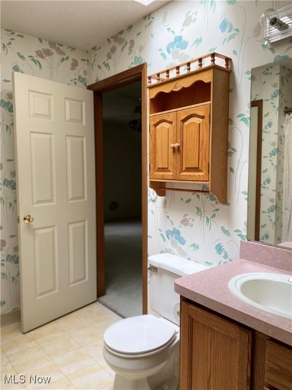312 Chesapeake Cv, Painesville, OH 44077 - bathroom featuring wallpapered walls, vanity, and toilet