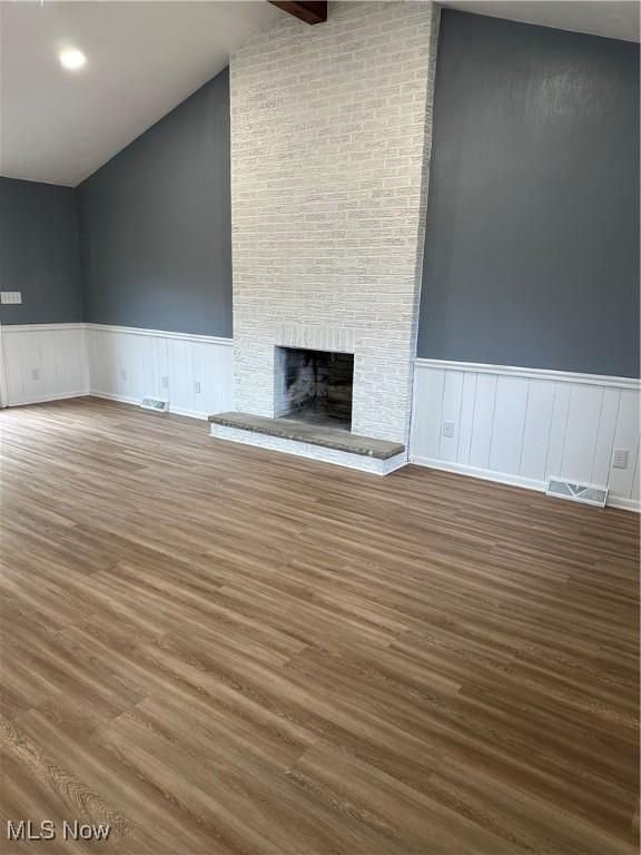 133 Bass Dr, Weirton, WV 26062 - unfurnished living room featuring visible vents, wainscoting, wood finished floors, and a fireplace
