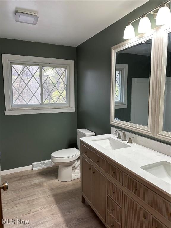 133 Bass Dr, Weirton, WV 26062 - bathroom with visible vents, double vanity, wood finished floors, toilet, and a sink