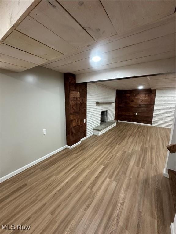 133 Bass Dr, Weirton, WV 26062 - finished below grade area with baseboards, a fireplace, wood walls, and wood finished floors
