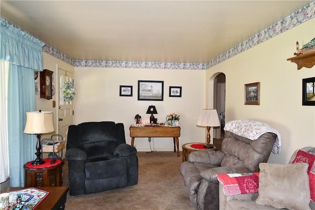living room with arched walkways, baseboards, and carpet flooring