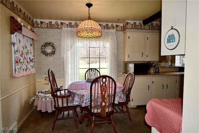 carpeted dining space featuring baseboards