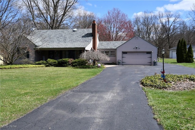 single story home with an attached garage, driveway, a chimney, and a front lawn