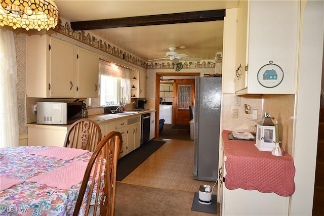 kitchen with freestanding refrigerator, a ceiling fan, washer / dryer, white microwave, and dishwashing machine