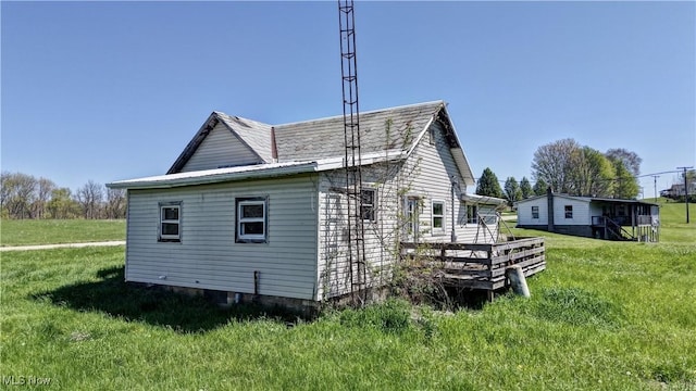 view of home's exterior featuring a lawn and a wooden deck