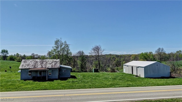 exterior space featuring an outdoor structure, an outbuilding, and a wooded view
