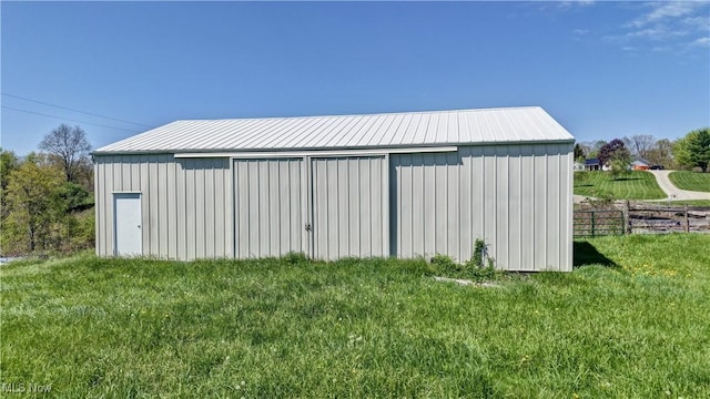 view of pole building with a lawn and fence