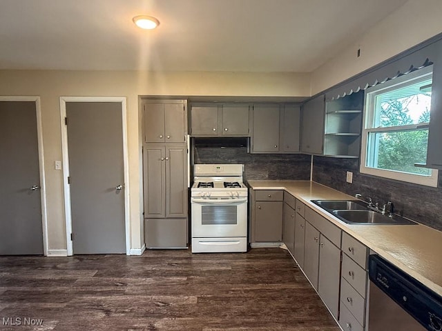 kitchen featuring gray cabinets, stainless steel dishwasher, a sink, white gas range oven, and dark wood-style floors