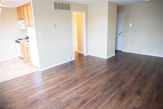 unfurnished living room featuring baseboards, visible vents, and wood finished floors