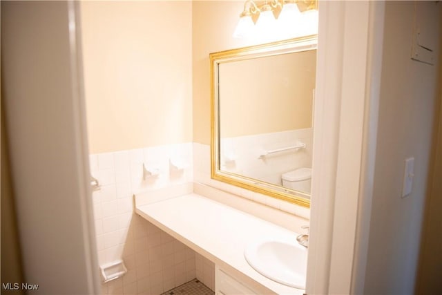bathroom with tile patterned flooring, vanity, toilet, and tile walls