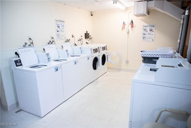 shared laundry area featuring baseboards, washing machine and dryer, and light floors
