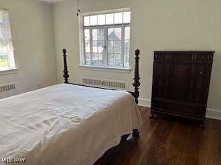 bedroom with radiator heating unit, baseboards, multiple windows, and dark wood-style floors