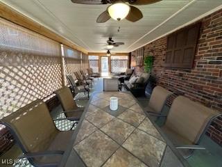 sunroom with brick wall and tile patterned floors
