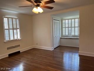 empty room with baseboards, a healthy amount of sunlight, and wood finished floors