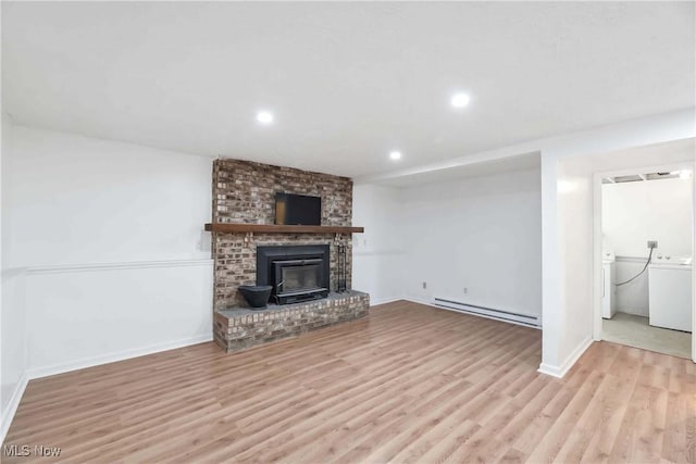 unfurnished living room with baseboard heating, wood finished floors, baseboards, washer / dryer, and recessed lighting