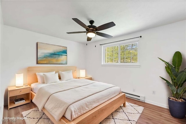bedroom with baseboards, ceiling fan, wood finished floors, and a baseboard radiator