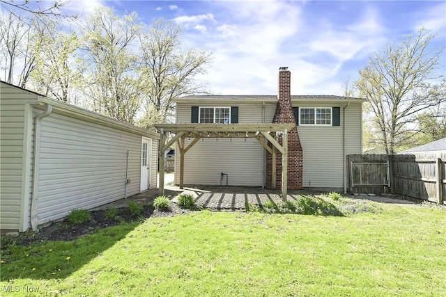 back of property featuring a yard, fence, a chimney, and a patio area