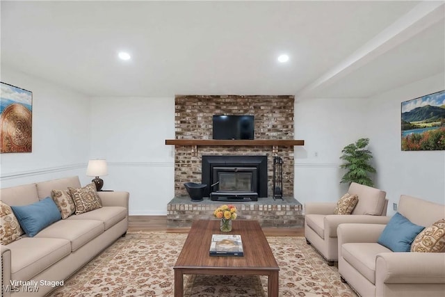 living area featuring recessed lighting, a brick fireplace, and wood finished floors