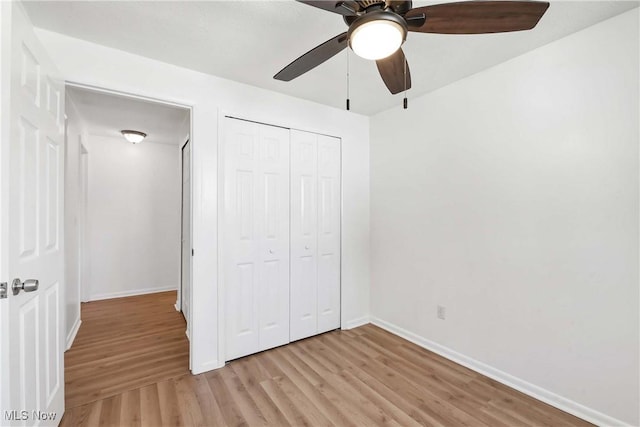 unfurnished bedroom with baseboards, a ceiling fan, light wood finished floors, and a closet