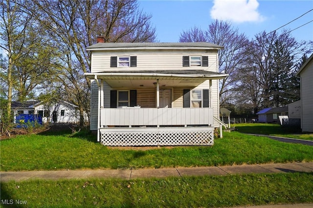 view of front facade with a porch, a chimney, and a front lawn