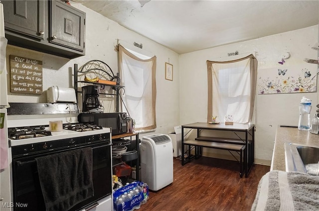 kitchen with black microwave, dark wood-style floors, light countertops, range with gas cooktop, and dark cabinetry