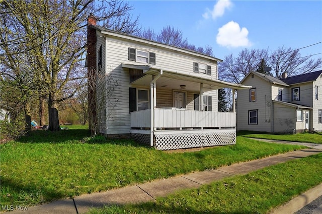 traditional home with a chimney, a porch, and a front lawn