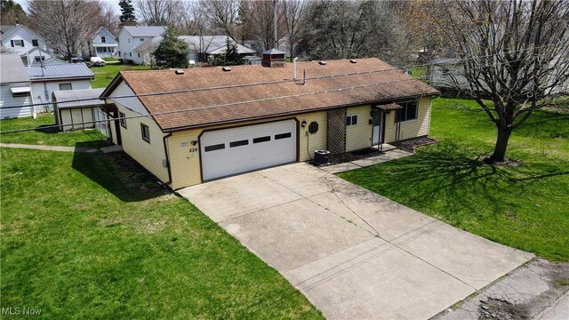 ranch-style home featuring fence, a shingled roof, concrete driveway, and a front yard