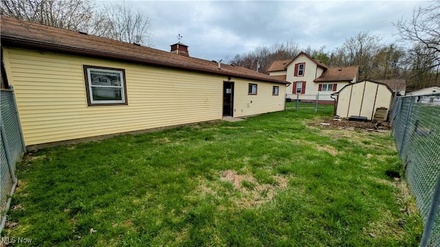 view of yard featuring a fenced backyard, a storage unit, and an outdoor structure