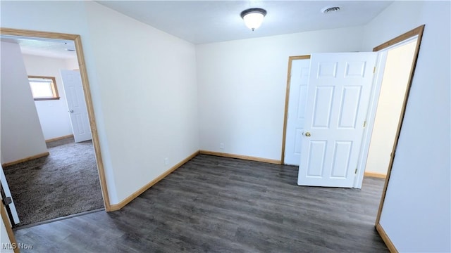 empty room with baseboards, wood finished floors, and visible vents
