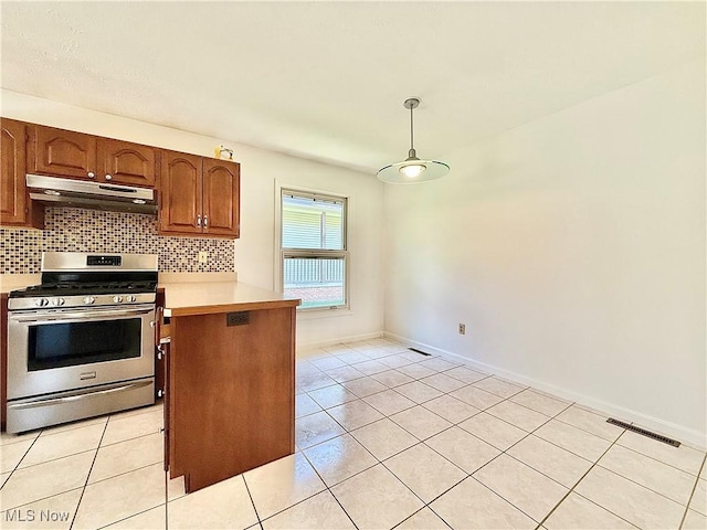 kitchen with a peninsula, light countertops, under cabinet range hood, stainless steel range with gas stovetop, and backsplash