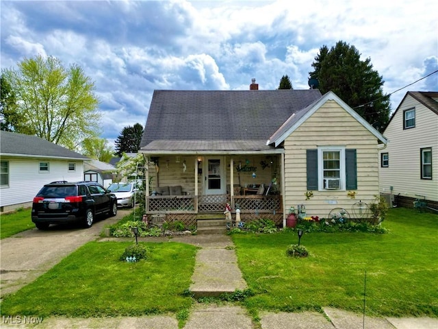 bungalow-style home with covered porch, a chimney, and a front yard