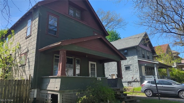 view of side of property with fence and a porch