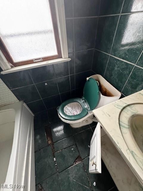 bathroom featuring vanity, tile patterned flooring, and tile walls