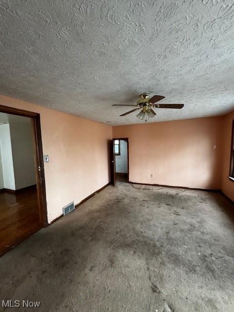 unfurnished room with visible vents, carpet, a textured ceiling, and ceiling fan