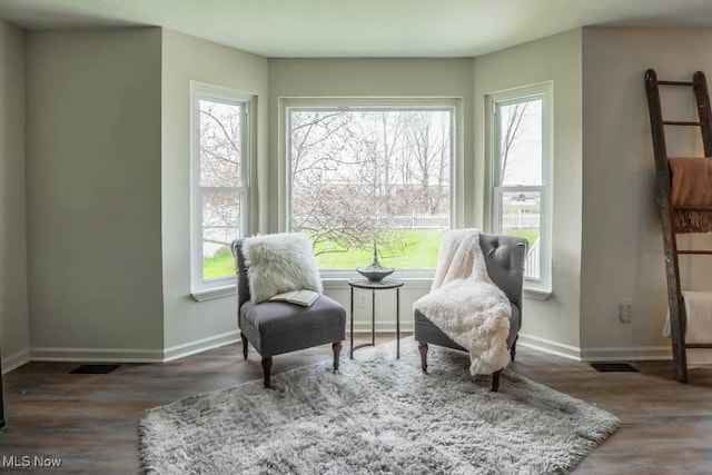 living area with baseboards, plenty of natural light, and wood finished floors