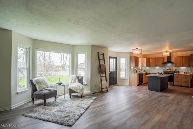 living area featuring an inviting chandelier, baseboards, dark wood-style flooring, and a textured ceiling