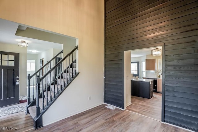 entryway featuring a healthy amount of sunlight, stairs, and wood finished floors