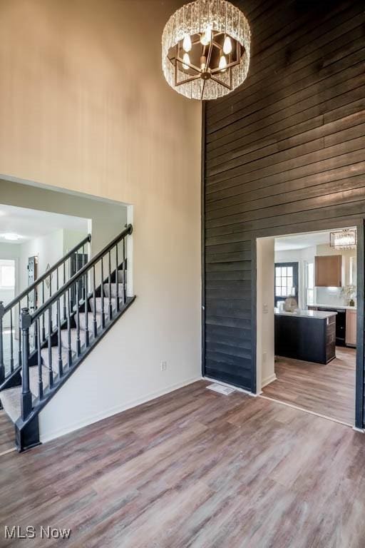 interior space featuring a high ceiling, an inviting chandelier, plenty of natural light, and stairway