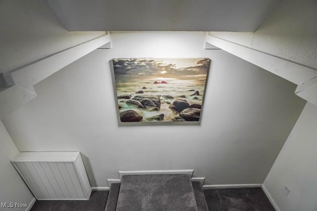 staircase featuring baseboards and carpet