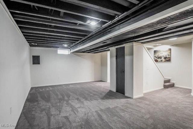 finished below grade area with baseboards, carpet, and stairs