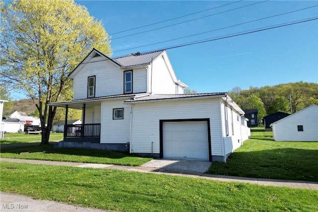 441 4th St, Bergholz, OH 43908 - view of front of property featuring a garage, metal roof, a porch, and a front lawn